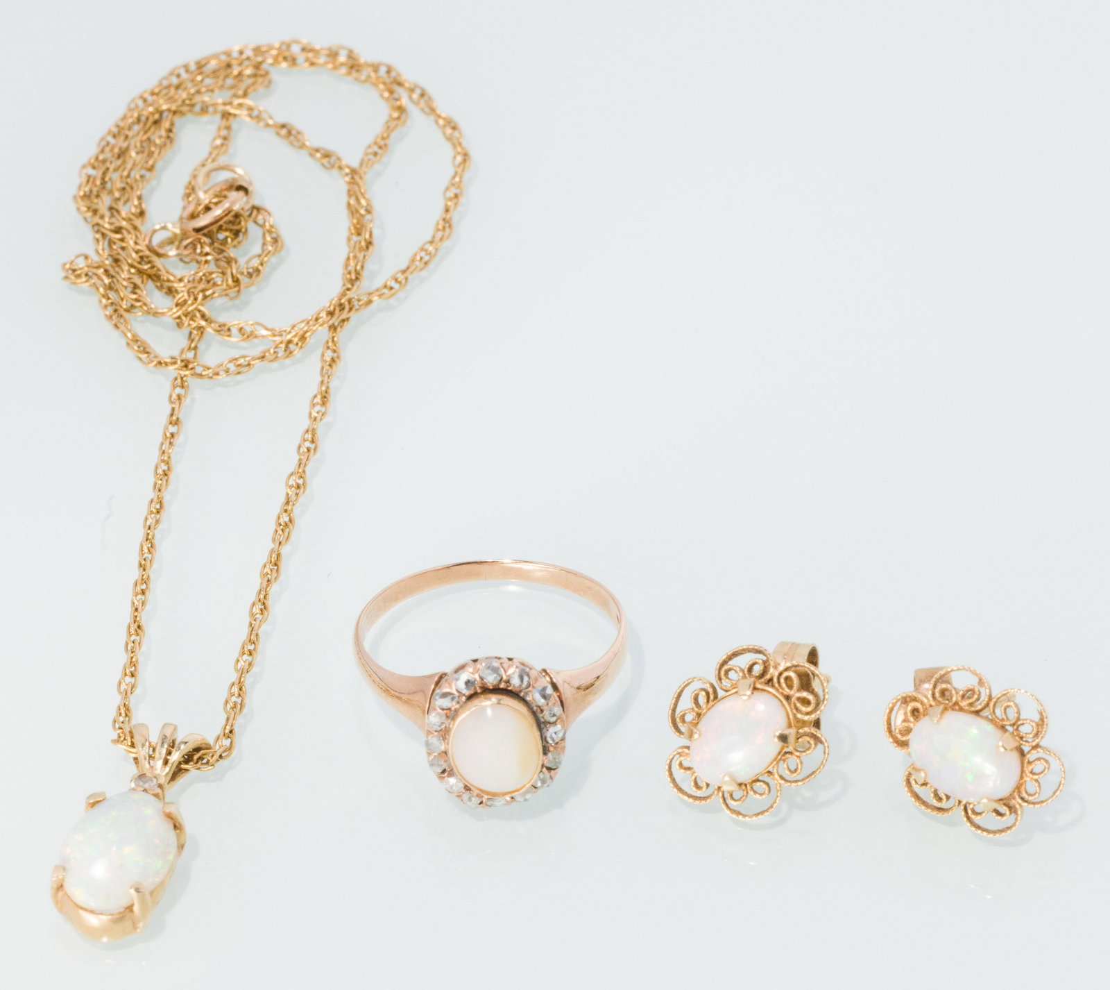 14K Gold and Opal Pendant with Earrings and a Ring: Description: 14K Gold and Opal Pendant with Earrings and a Ring, comprising a 14K, opal and diamond pendant on a 14K chain (marked '14K' on clasp and pendant loop), a pair of opal and gold stud e