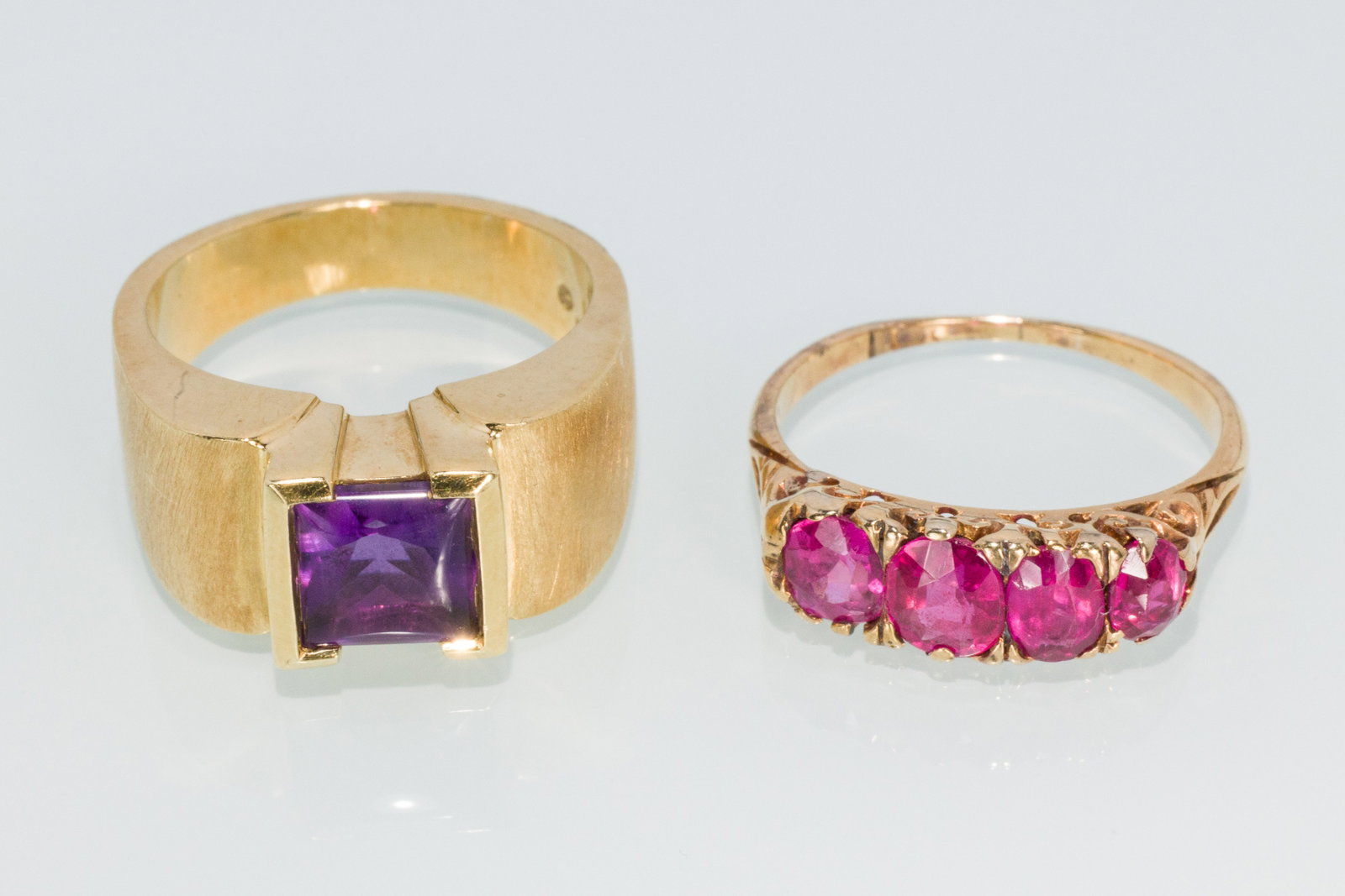 Two Ladies Gold Rings: Property from a Private Collection, Jacksonville, FL Description: Two Ladies Gold Rings, a 18K yellow gold contemporary setting hallmarked 'JA, 18K' with a square cabochon amethyst, size 7 (12.38
