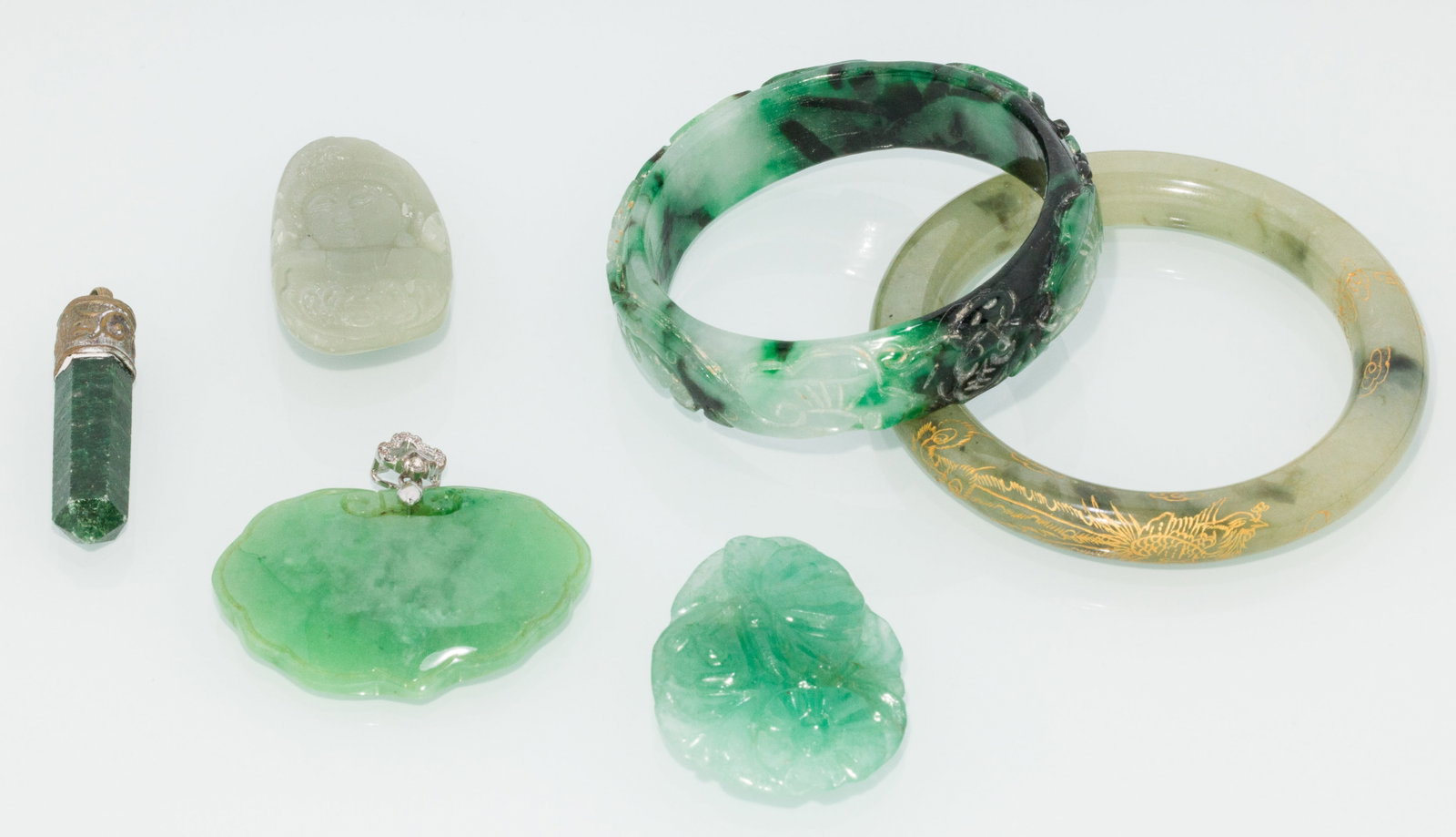 Two Jade Bangles and Four Pendants: Description: Two Jade Bangles and Four Pendants, comprising a smooth jade bangle decorated with clouds and phoenix, a carved jade bangle with flowers and vines, a jade pendant carved with flowers