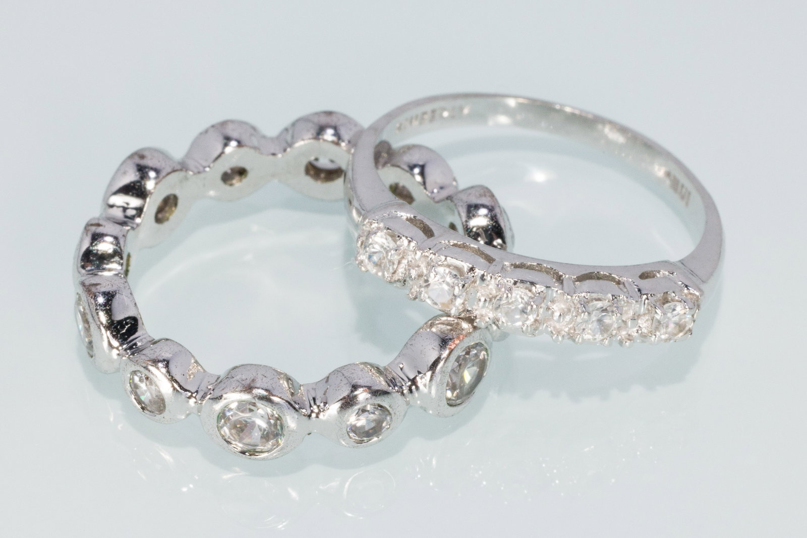 Two Ladies Rings: Property from a Private Collection, Jacksonville, FL Description: Two Ladies Rings, a 10K white gold vintage band featuring 5 round topaz hallmarked 'Kimberly', size 6.5 (1.7 grams overall); along