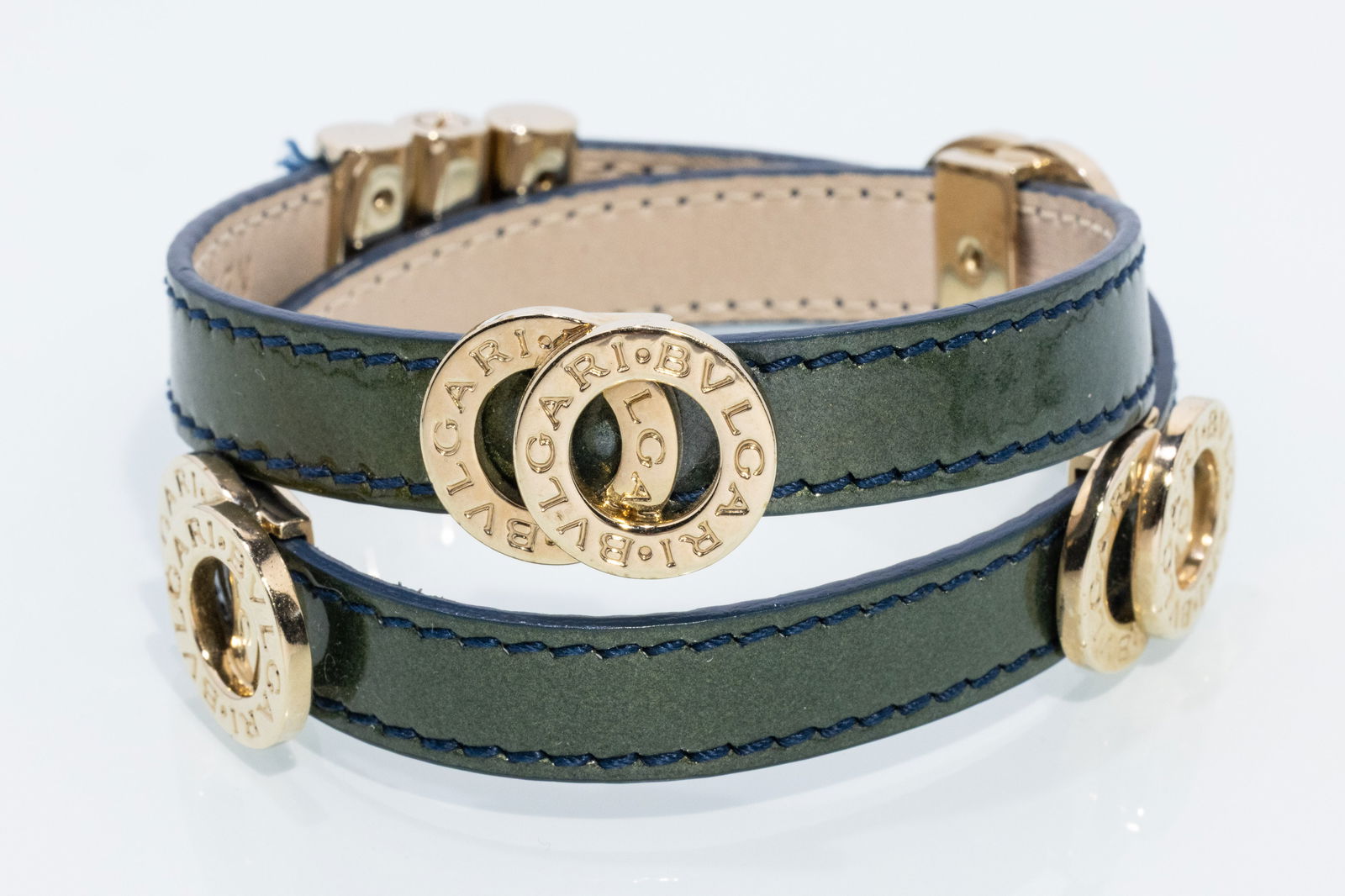 Bulgari Leather Wrap Bracelet: Description: Bulgari Leather Wrap Bracelet, blue/green leather wrap bracelet with gold-tone hardware and sliding clasp, marked 'Bulgari, made in Italy' and 'NE, A10, 31747' on inside of leather.
