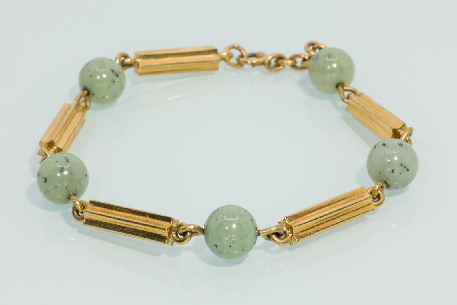 14K Gold and Jade Bracelet: Property from the Estate of Arthur B. Kouwenhoven Jr., Savannah, GADescription: 14K Gold and Jade Bracelet, 14K yellow gold chain with long gold beads alternating with round celadon speckled jade