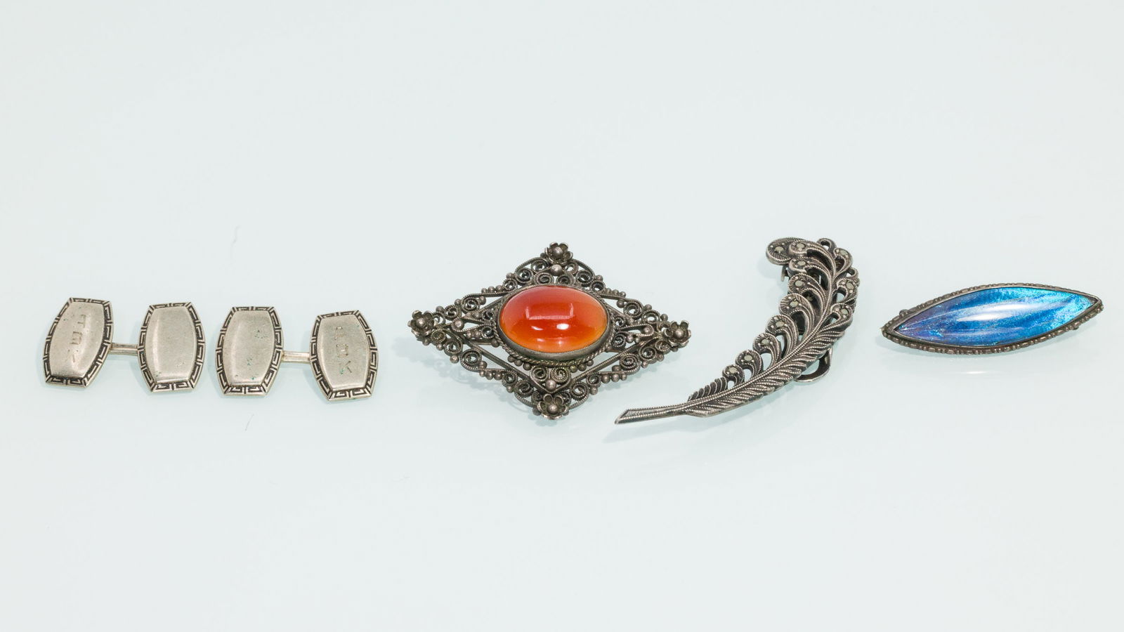 Three Silver Pins and a Pair of Cuff Links: Property from the Estate of Arthur B. Kouwenhoven Jr., Savannah, GA Description: Three Silver Pins and a Pair of Cuff Links, comprising a continental silver brooch with red glass cabochon (marked