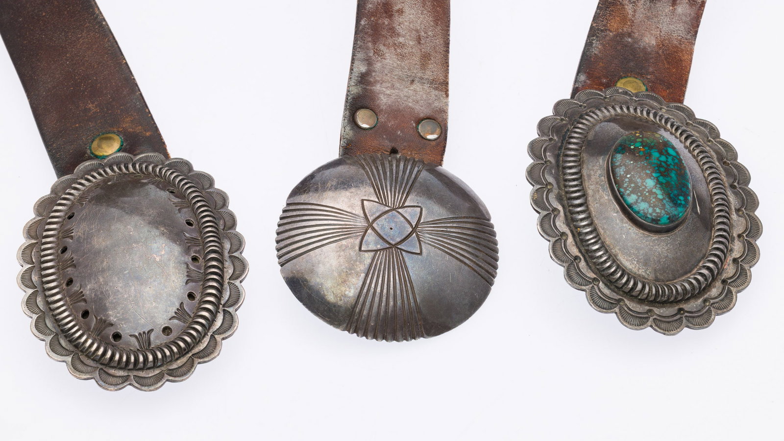 3 Orville Tsinnie Navajo Belt Buckles: Property from the Estate of Arthur B. Kouwenhoven Jr., Savannah, GADescription: 3 Orville Tsinnie Navajo Belt Buckles, One with Turquoise, comprising a 4 in. x 3 in. sterling silver buckle with oval