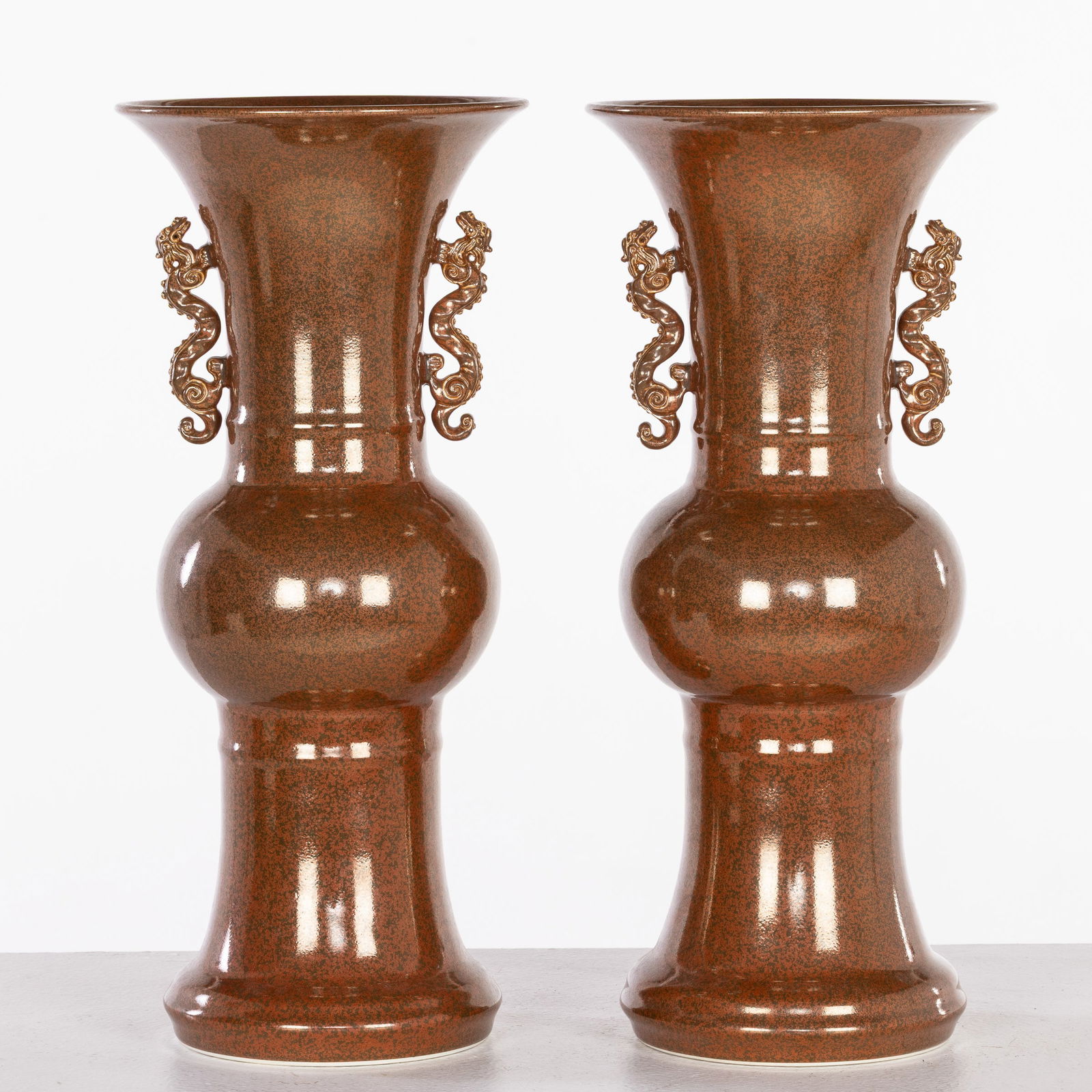 Pair of Chinese Red Speckled Glazed Ceramic Vases: Property from the Estate of Arthur B. Kouwenhoven Jr., Savannah, GADescription: Pair of Chinese Red Speckled Glazed Ceramic Vases, each of Gu form with dragon-form handholds, marked on the