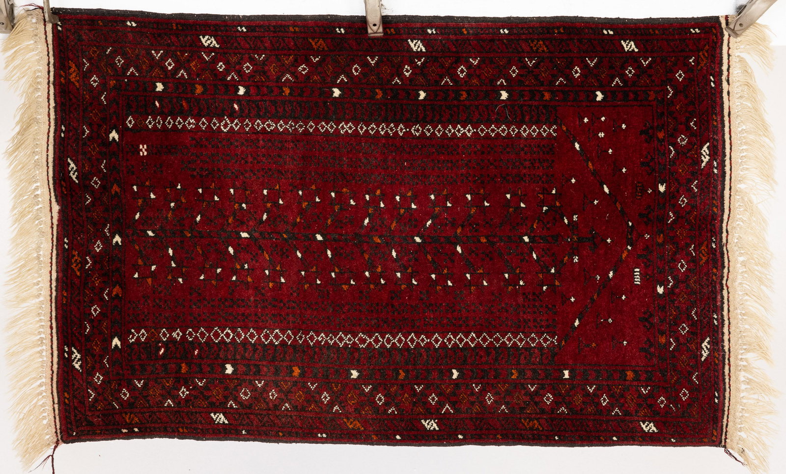 Small Tribal Rug: Property from the Estate of Arthur B. Kouwenhoven Jr., Savannah, GADescription: Small Tribal Rug, in tones of cream, navy, and orange on a red ground.Measurements: Length: 3 ft. 10 in. x Width: 2 ft.