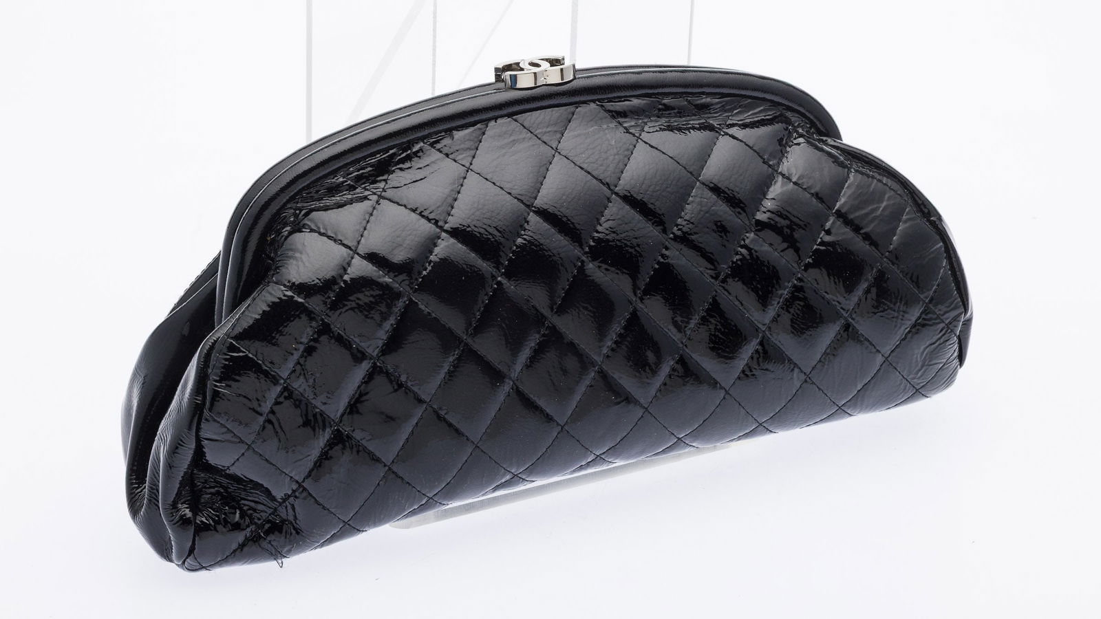 Chanel Quilted Patent Leather Clutch: Property from a Private Collection, St. Simons Island, GADescription: Chanel Quilted Patent Leather Clutch, black quilted patent leather clutch with silver-tone 'CC' logo clasp, the hinged framed top