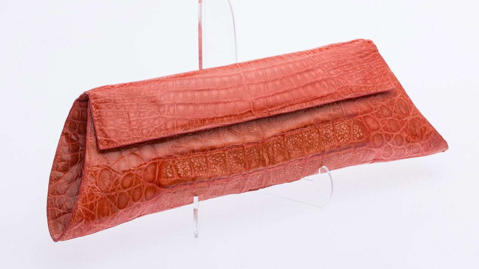 Nancy Gonzalez Orange Crocodile Clutch: Property from a Private Collection, St. Simons Island, GADescription: Nancy Gonzalez Orange Crocodile Clutch, long blood-orange tone clutch, the flap top with magnetic closure, opening to a suede