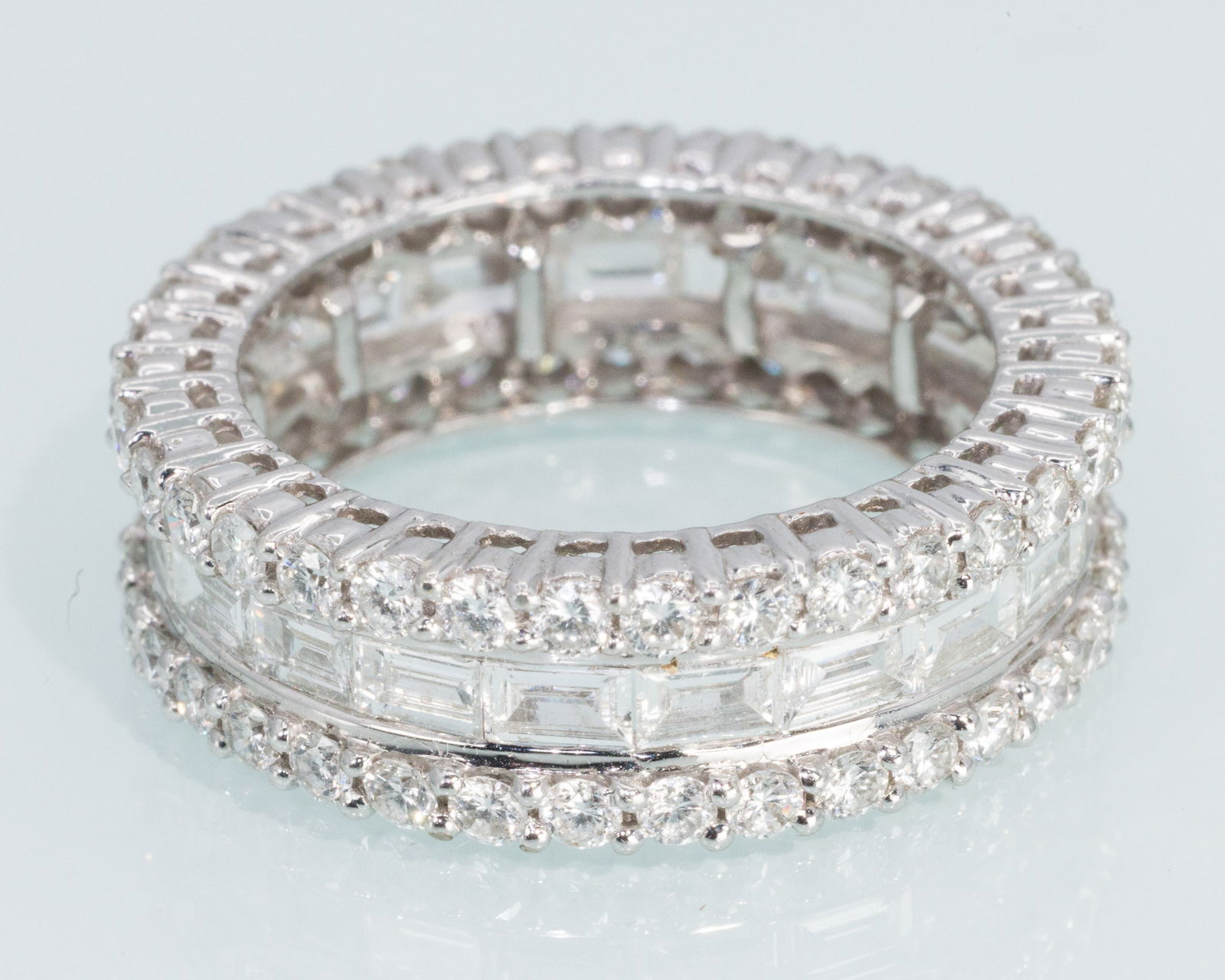 Diamond and 18K Gold Infinity Band: Description: Diamond and 18K Gold Infinity Band, 18K white gold band set with a row of baguette diamonds between two rows of round cut diamonds (approx. 15.2 cts, F-G VS2-SI), the inside of band