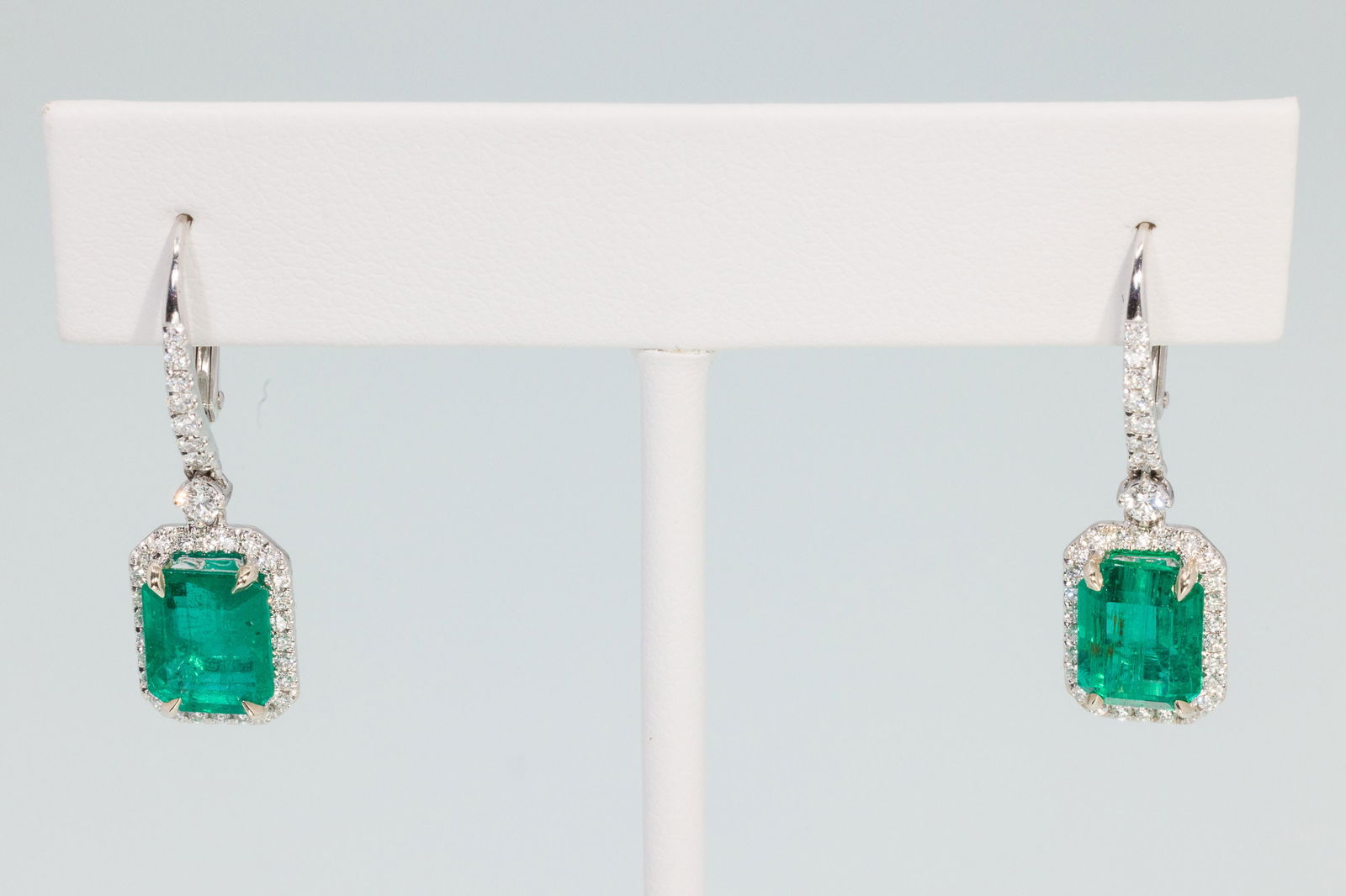 14K Gold, Emerald and Diamond Earrings: Description: 14K Gold, Emerald and Diamond Earrings, 14K white gold earrings featuring emerald drops (approx. 7-8 cts, 8.62. mm x 6.96 mm and 8.38 mm x 6.31 mm) with diamond halo and diamond lined