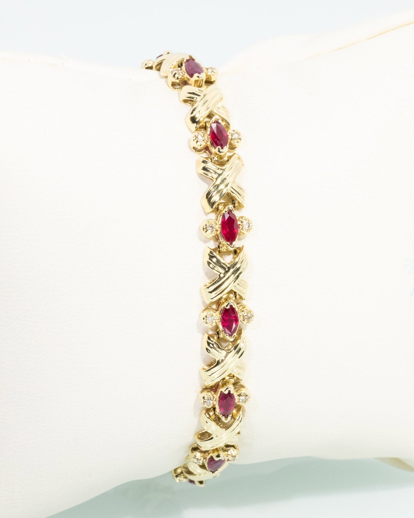 Ruby, Diamond and 14K Gold Bracelet: Description: Ruby, Diamond and 14K Gold Bracelet, 14K yellow gold bracelet with x-form links, featuring 14 lozenge cut rubies, each flanked by two small round diamonds, with box clasp, marked '14