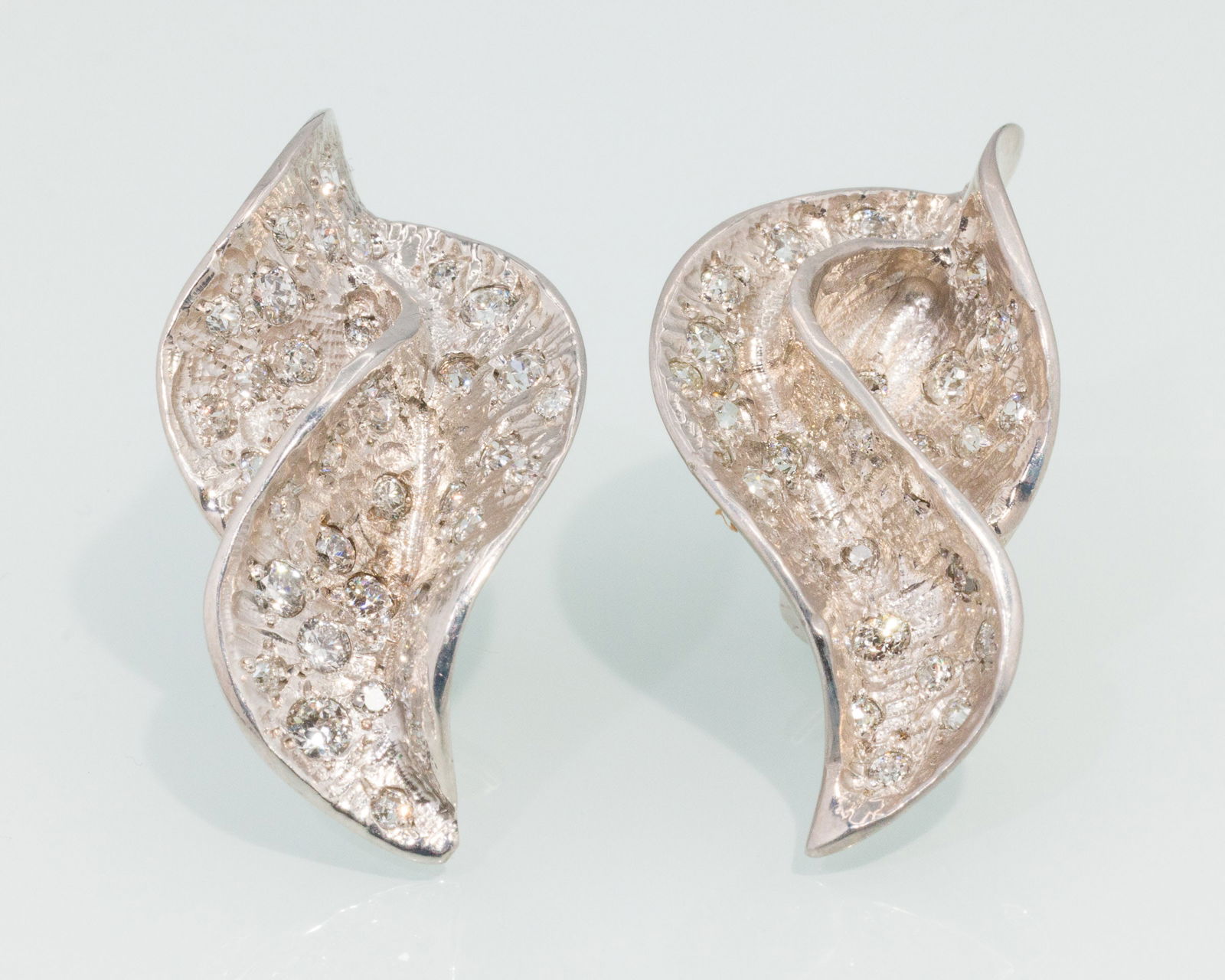 14K Gold and Diamond Earrings: Description: 14K Gold and Diamond Earrings, 14K white gold leaf-form earrings featuring various flush mounted round diamonds (approx. 5-6 cts, VS), with post and clip backs, marked '14K' on clips.