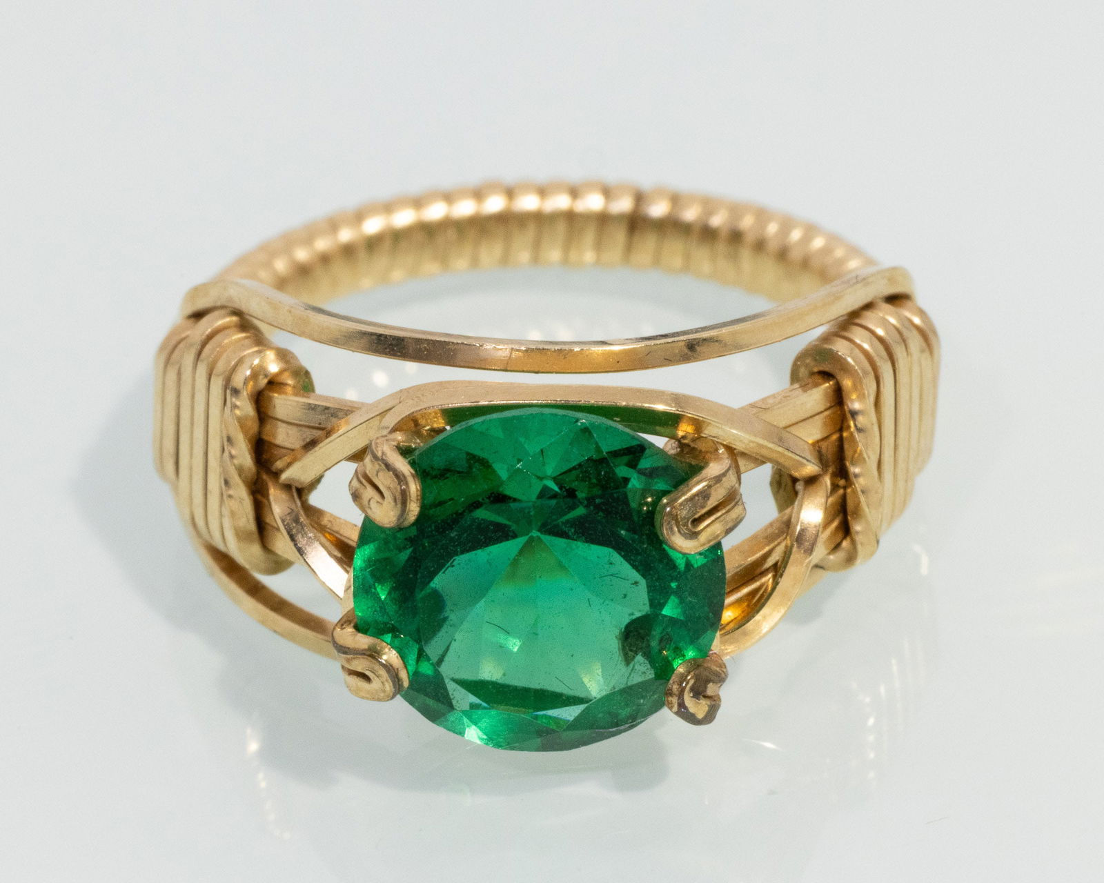 14K Gold and Possibly Demantoid Ring: Description: 14K Gold and Possibly Demantoid Ring, 14K gold wire wrap ring with round faceted deep green gem (possibly Demantoid), unmarked. 3.24 grams.Measurements: Size: 5.5