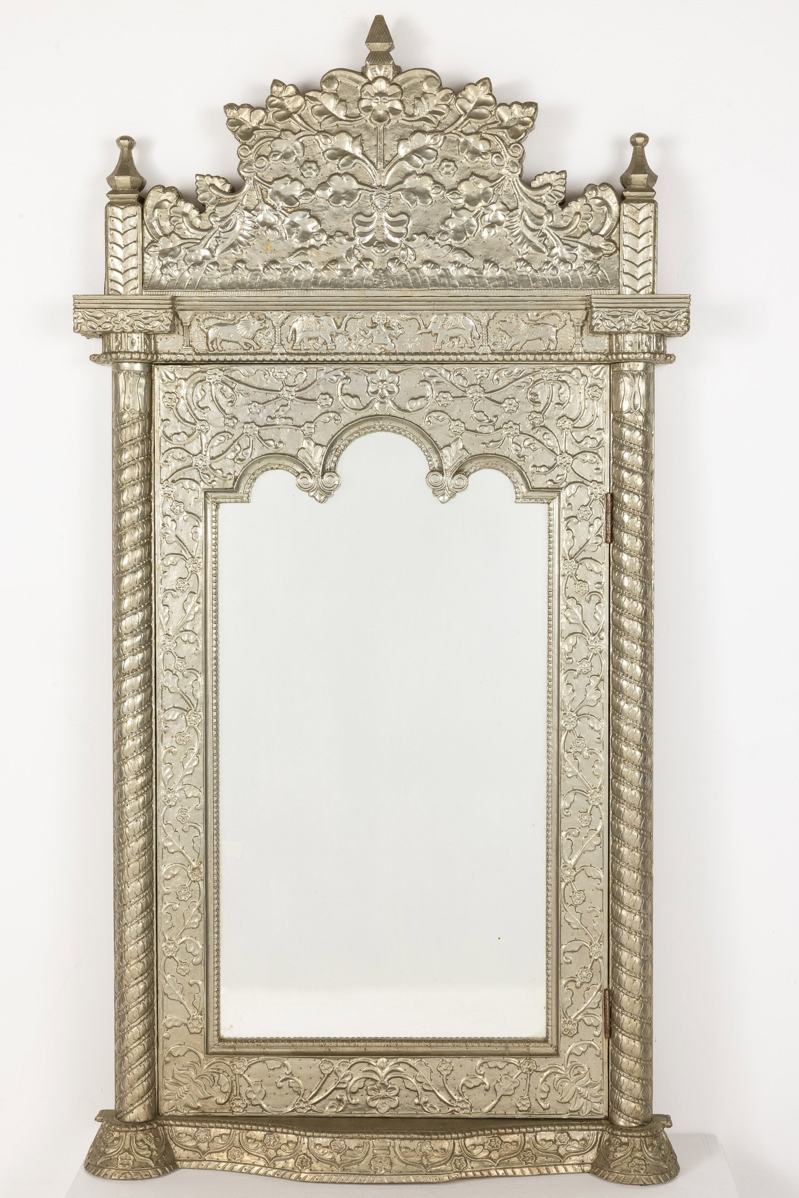 Indian Metal Mounted Mirror: Property of a Private Collector, Savannah, GA Description: Indian Metal Mounted Mirror, the shaped mirror plate surmounted by an arched cornice and flanked by columns, on a shaped base, the mirror