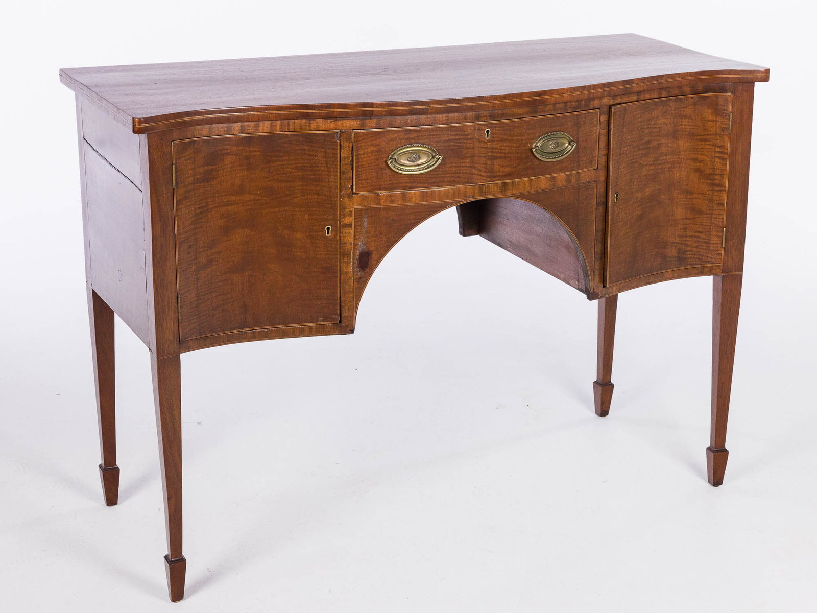 George III Style Mahogany Sideboard: Property of a Private Collector, Savannah, GA Description: George III Style Mahogany Sideboard, with serpentine front over a drawer and cabinet doors, raised on square tapering legs ending in spad
