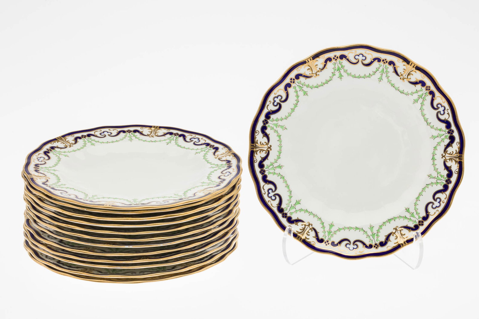 13 Royal Crown Derby Plates, Retailed by Tiffany: Property from a Private Collection, New York City Description: 13 Royal Crown Derby Plates, Retailed by Tiffany, retailed by Tiffany & Co, each with green, blue and gilt decorated rims, marked in red