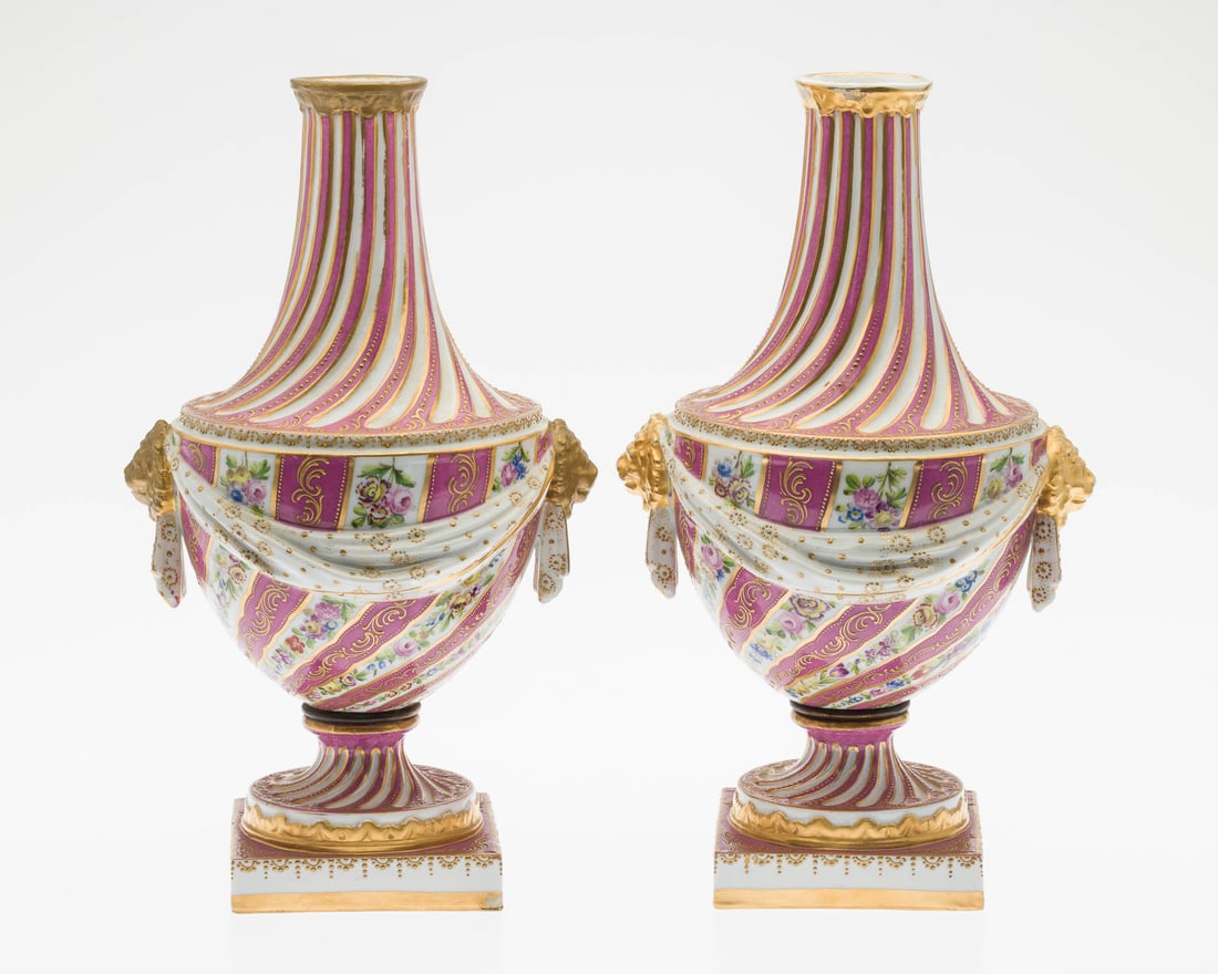 Pair of Sevres Style Porcelain Pink and White Urns: Property from a Private Collection, New York City Description: Pair of Sevres Style Porcelain Pink and White Urns, each with lion-form handles, decorated with flowers and accented in gilt, marked in