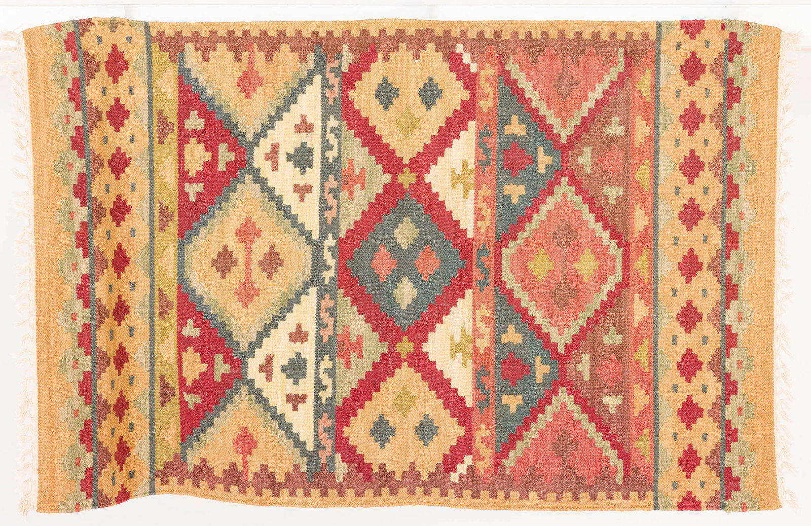 Kilim Rug: Property of Bliss Hebert and Allen Charles Klein Description: Kilim Rug, in tones of red, light green, beige, dark blue and ochre with diamond decoration on a beige ground. Measurements: Length: 60