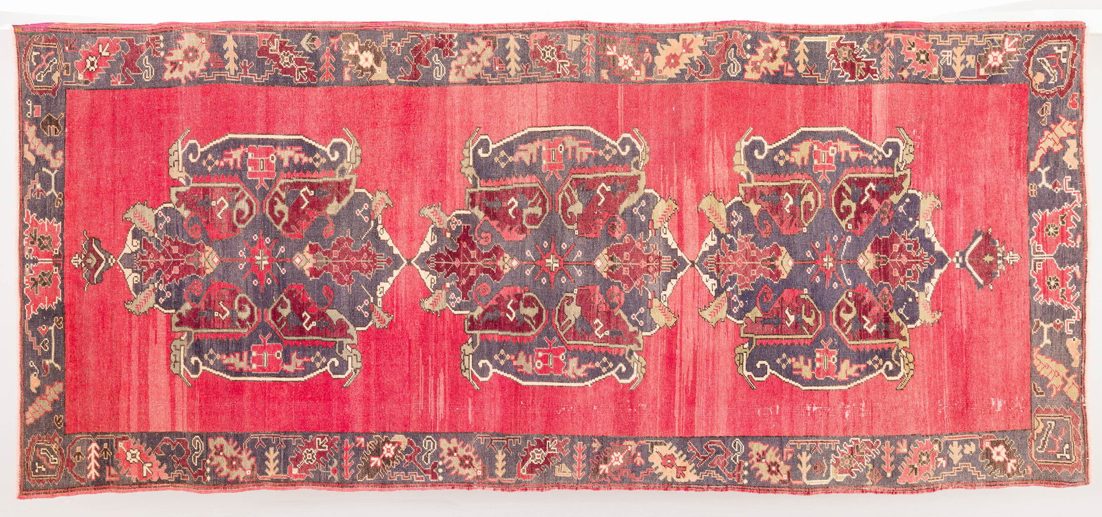 Turkish Salmon Wool Rug: Property of a Private Collector, St. Helena Island, SC Description: Turkish Salmon Wool Rug, in tones of dark blue, red, green on a red ground. Measurements: Length: 12 ft. 2 in