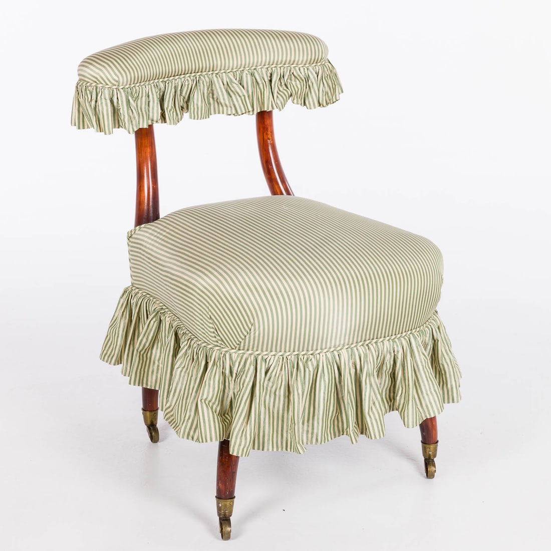 Victorian Walnut Slipper Chair, 19th C: Property of a Private Collector, Savannah, GA Description: Victorian Walnut Slipper Chair, 19th C, with upholstered backrest and seat with skirt, raised on outflared legs with caps and casters.