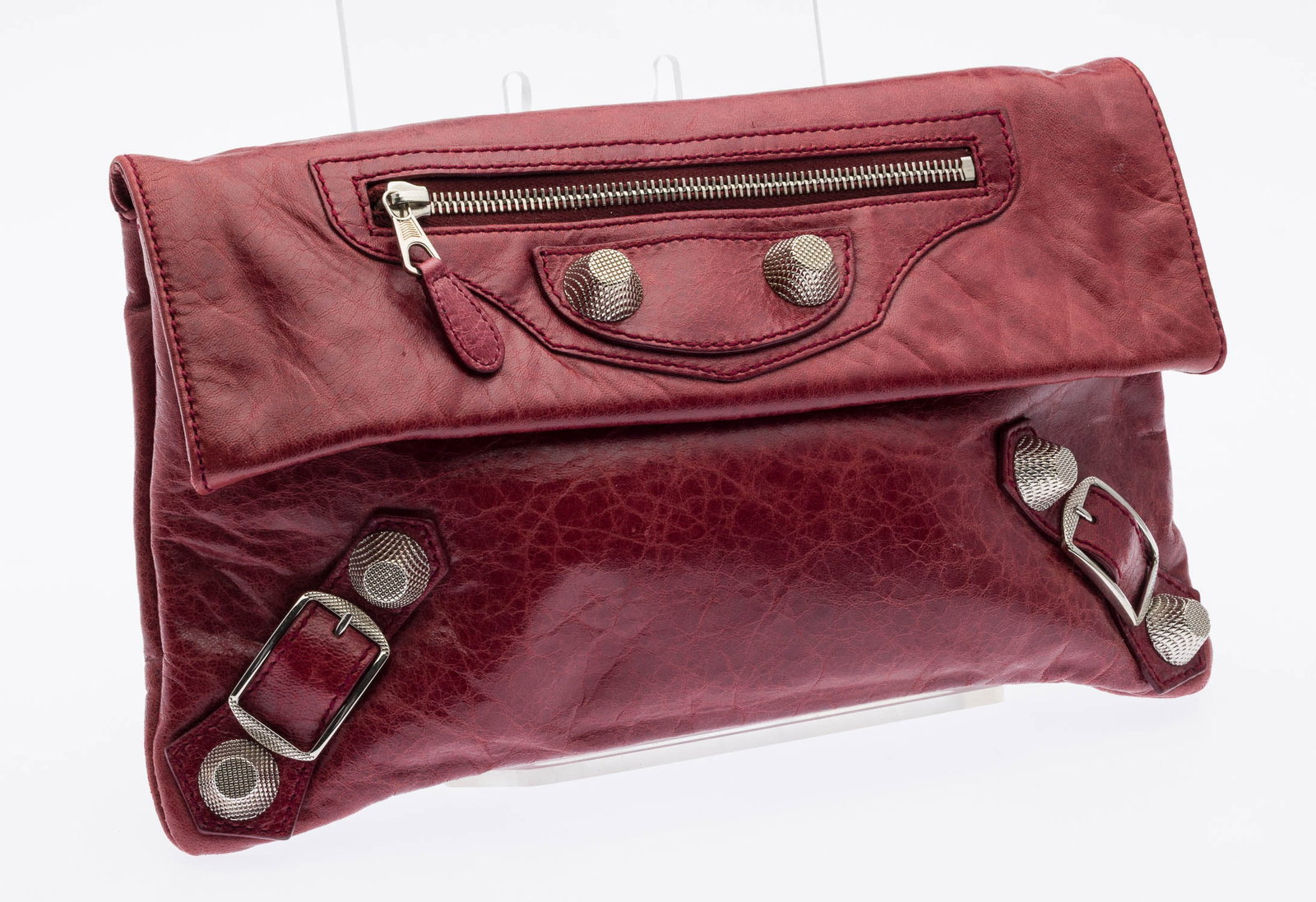 Balenciaga Giant 21 Envelope Clutch: Description: Balenciaga Giant 21 Envelope Clutch, red lambskin piece from the brand's "Motocross" collection, with silver-tone studs and matching buckles at the bottom corners, fold-over magnetic