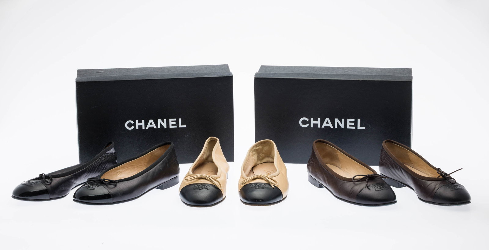 3 Pairs Chanel Cap Toe Ballerina Flats, Sz 37/36.5: Description: 3 Pairs of Chanel Cap Toe Ballerina Flats, Sz 37/36.5, comprising Chanel Brown and Black Leather ballet flats with stitched CC logo and a bow detail, together with dust bags and box