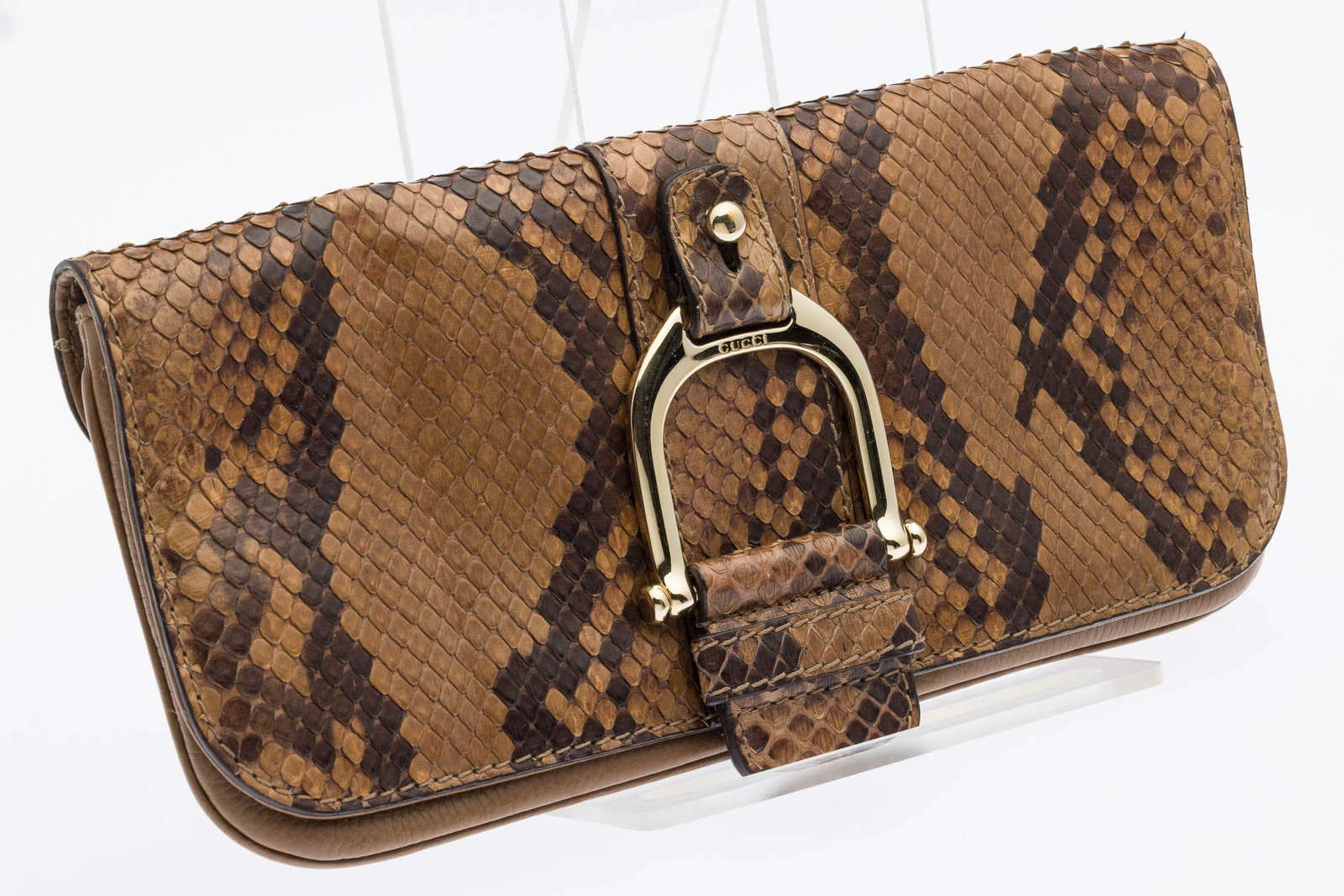 Gucci Greenwich Python Small Leather Clutch: Description: Gucci Greenwich Python Small Leather Clutch, with a light gold-tone stirrup-style embellishment on the front flap closure and a beige canvas interior, featuring an internal leather tab