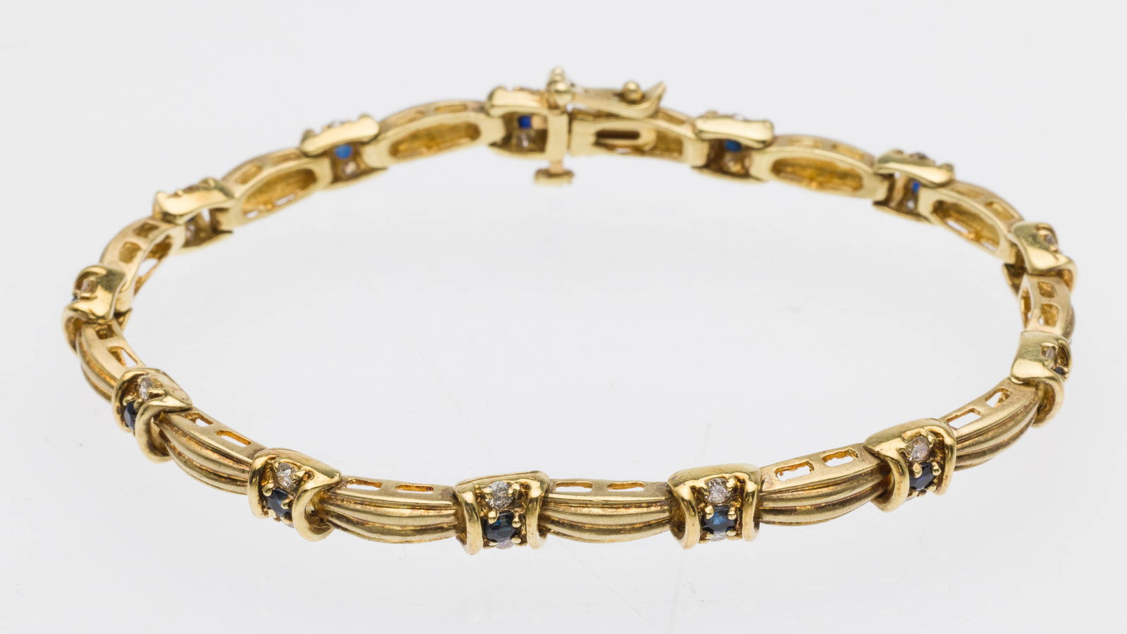 14K Gold Diamond and Sapphire Tennis Bracelet: Property from a Private Collection, Savannah, GA Description: 14K Gold Diamond and Sapphire Tennis Bracelet, featuring round cut sapphires and diamonds set in 14K yellow gold links with box clasp,