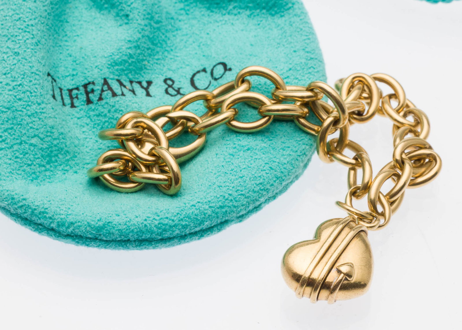 Tiffany & Co 18K Gold Heart Charm Bracelet: Property from a Private Collection, Savannah, GA Description: Tiffany & Co 18K Gold Heart Charm Bracelet, the chain with claw clasp marked '750' with heart and arrow charm, marked '1994, Tiffany &