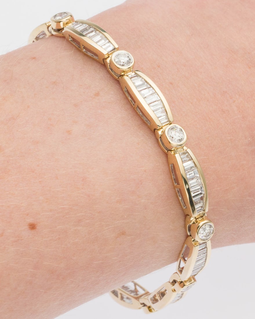 14K Gold and Diamond Bracelet: Description: 14K Gold and Diamond Bracelet, featuring round and baguette diamonds (approx. 6-7 cts, G-H VS2-SI) set in 14K yellow gold, with box clasp, marked '14K' on back of clasp. 14.75 grams.