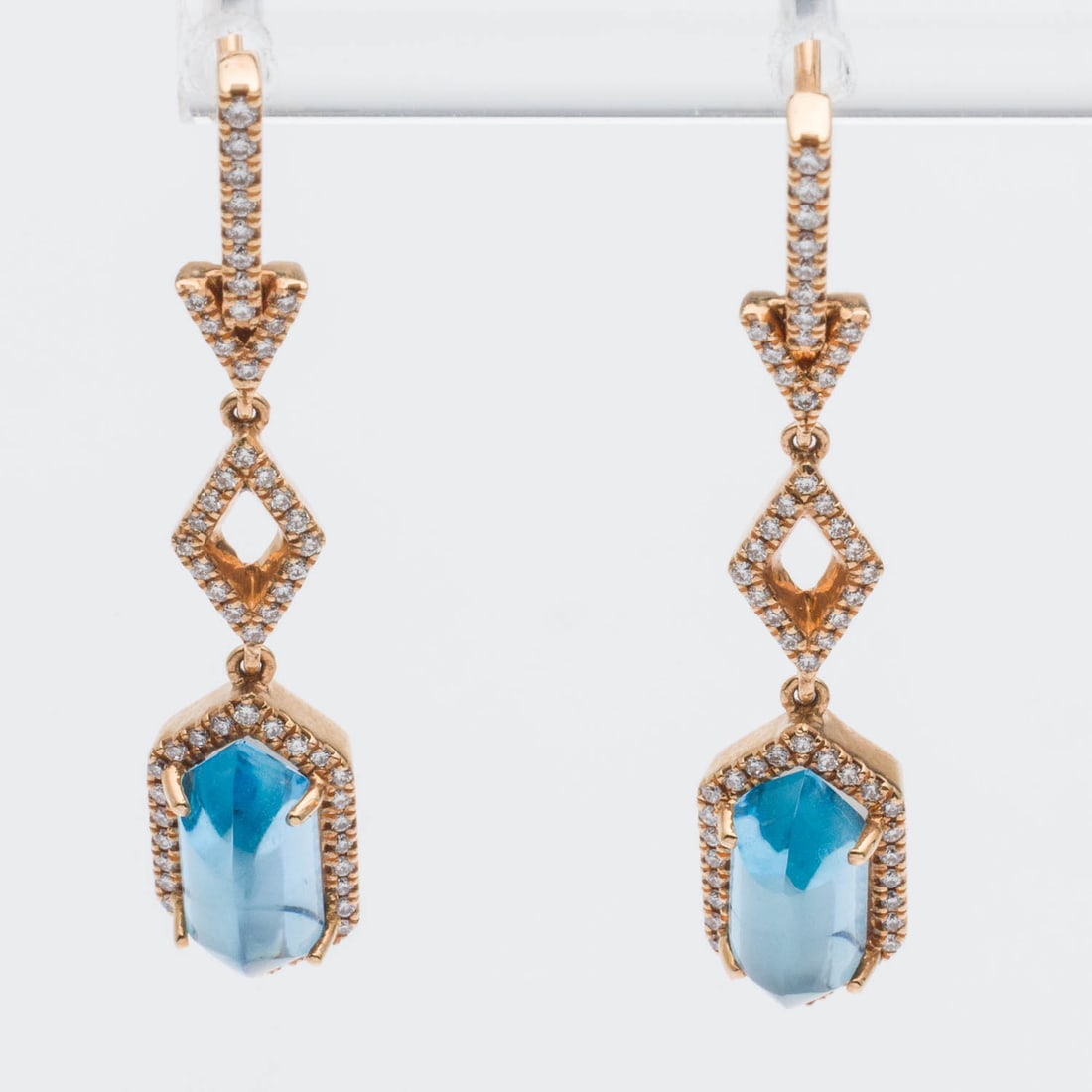 18K, Blue Topaz and Diamond Earrings: Description: 18K, Blue Topaz and Diamond Earrings, each featuring a beveled blue topaz cabochon accented with numerous near colorless round diamonds (approx. 0.60 cts), mounted in yellow gold wit