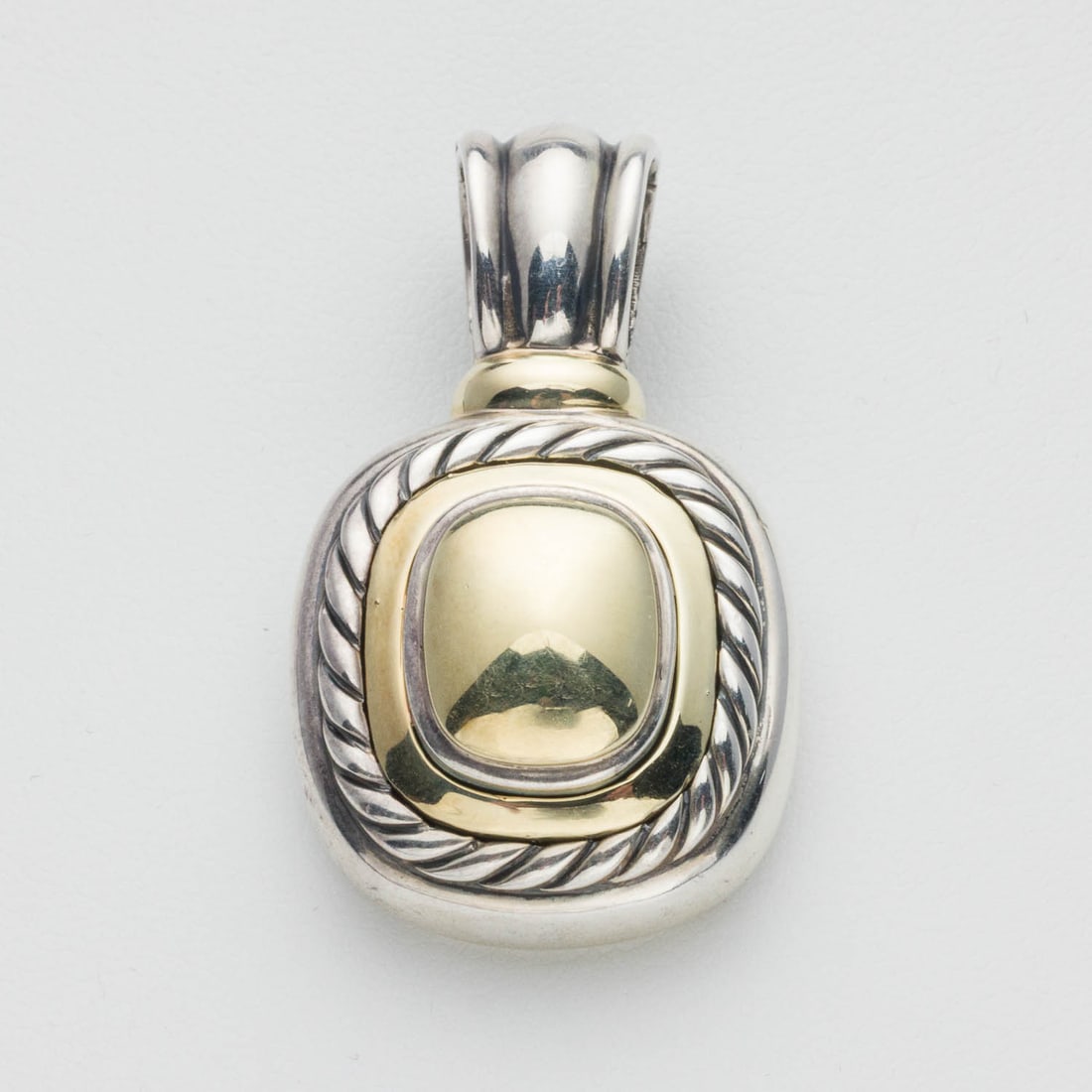 David Yurman Sterling Silver and 14K Gold Pendant: Property from a Private Collection, Savannah, GA Description: David Yurman Sterling Silver and 14K Gold Pendant, rounded square-form pendant in sterling silver and yellow gold, stamped 'DY' on bac