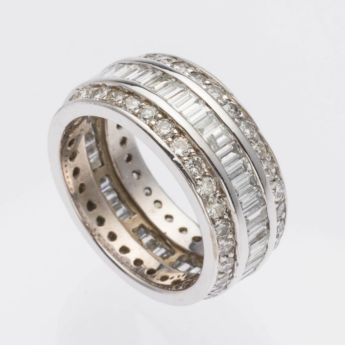 Triple Diamond and 14K Infinity Band, Size 7: Description: Triple Diamond and 14K Infinity Band, Size 7, featuring two rows of round diamonds with central band of baguettes (approx. 6.5 cts F-G, VS-SI), mounted in white gold, unmarked but tests