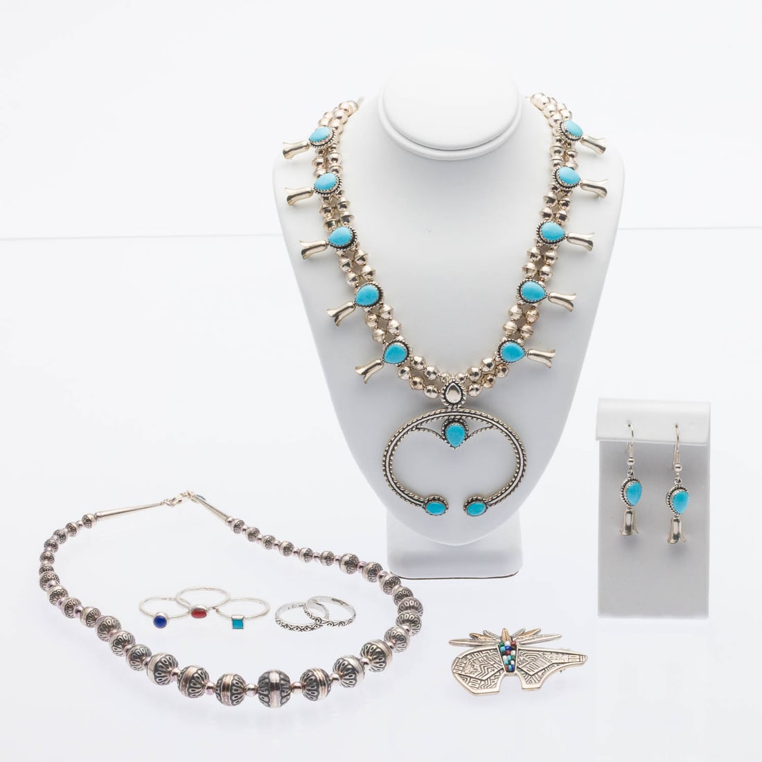 Sterling Silver and Turquoise Jewelry, 9 pcs.: Property from a Private Collection, Savannah, GA Description: Sterling Silver and Turquoise Jewelry, 9 pcs., comprising a sterling silver and turquoise necklace with squash blossom design (marked