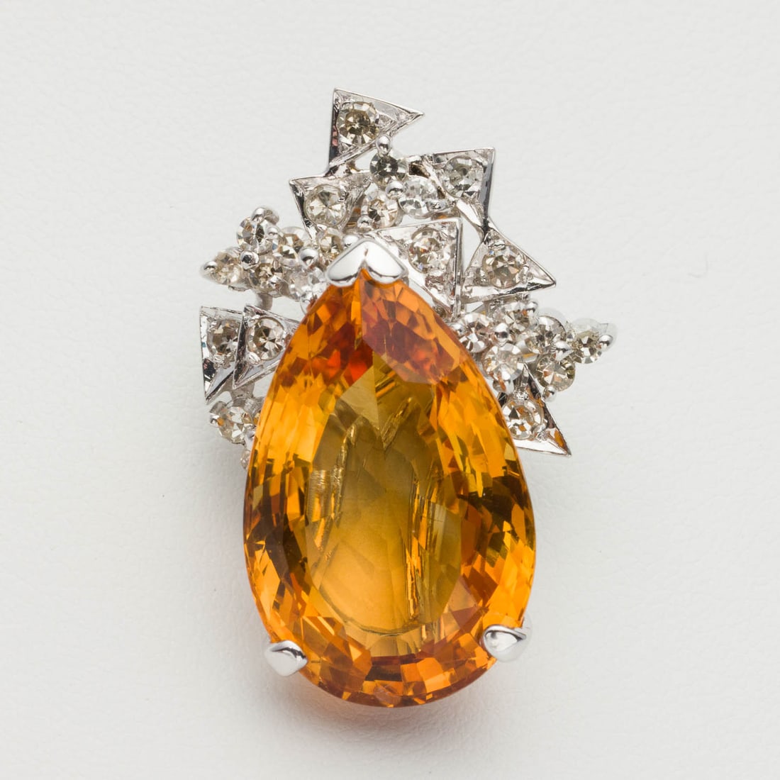 Citrine and Diamond Pendant: Property from a Private Collection, Jacksonville, FL Description: Citrine and Diamond Pendant, featuring a large pear cut citrine surmounted by triangle and clover designs with round cut diamonds,