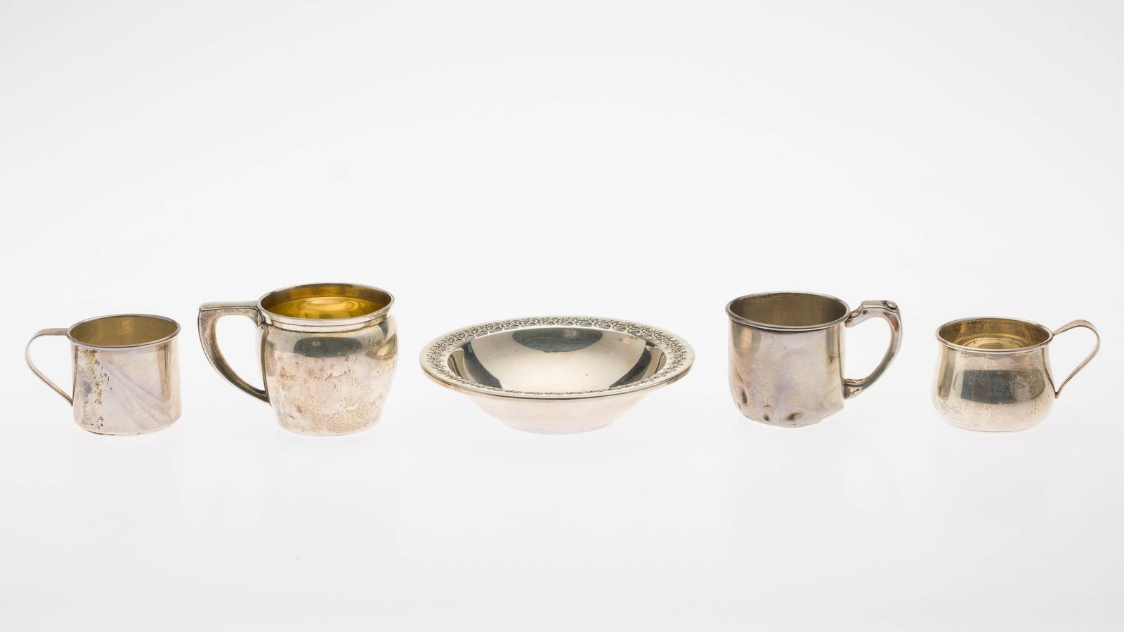 Four Sterling Silver Baby Mugs and a Bowl: Property from a Private Collection, Savannah, GA Description: Four Sterling Silver Baby Mugs and a Bowl, comprising two International baby mugs and International bowl with grape ornament, Whiting mug