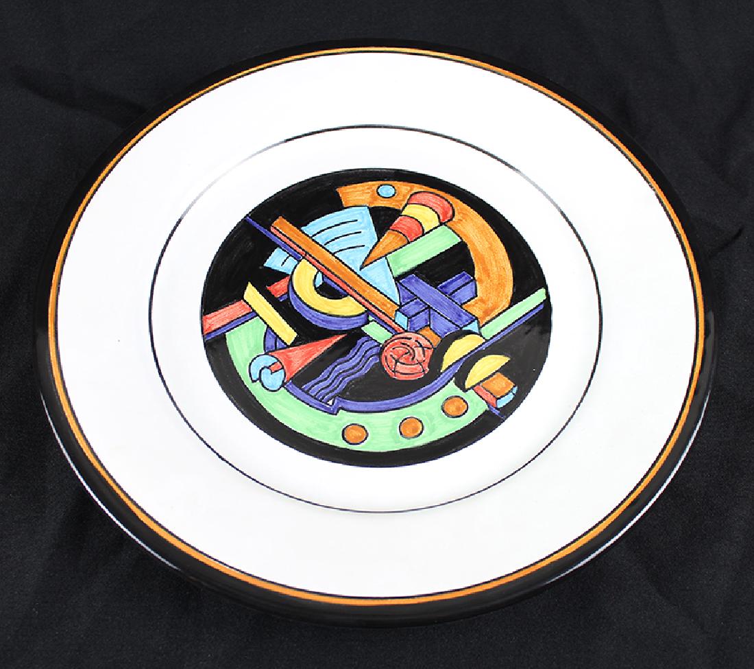 John Okulick (b. 1947) Californian: GRINDER, painted and glazed ceramic plate, made in Italy, signed on verso, 11 ¼” diameter, in good condition. Provenance: Appraisal from artist’s studio.