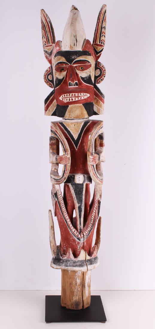 Oceanic Totemic Ancestral Statue: STANDING FIGURE, elaborately carved wood statue with clay and pigment, 50 x 10 x 10” with metal stand. From the collection of Selma & Herbert Moskowitz.