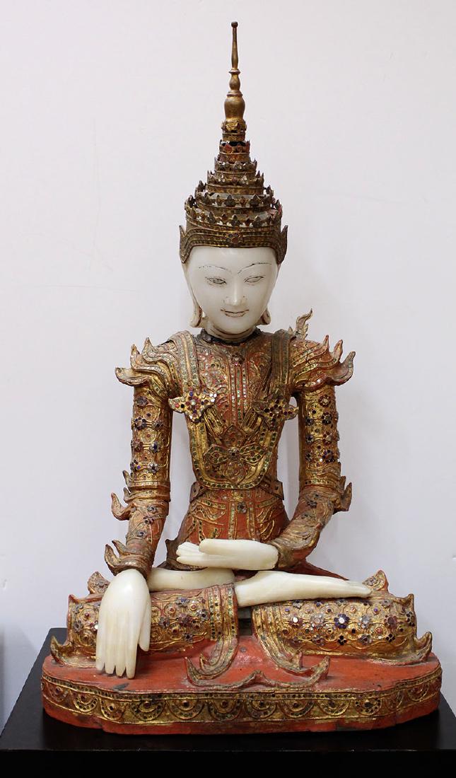 Asian Decorative Art: Thai Statue: SEATED BUDDHA, carved and painted wood with embedded colored glass and metal with carved white stone head and hands and feet, 31 x 18 x 13”, comes with a laminated wood stand 40 ½ x 19 x 14 ¾”. 