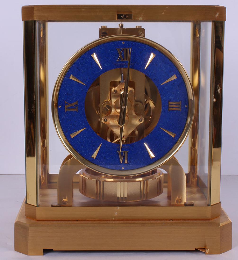 Jaeger Le Coultre Atmos Clock: Swiss perpetual motion brass clock with round Lapis Lazuli face and glass casing, stamped Le Coultre 446360, height 9 1/8Â”, width 8 ½Â”, depth 6 ½Â”. From the private collection of Academy