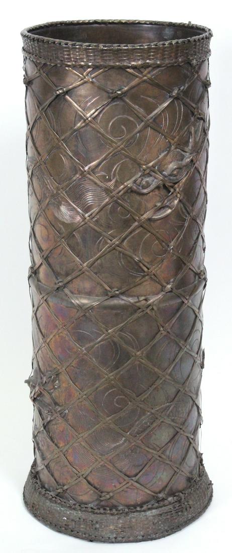 Decorative Art: Asian Umbrella Stand: Patinated brass or bronze umbrella stand with dragon motif and ribbon network overlay, with inscriptions on inside bottom, 24” tall, 10” diameter, weight 15 pounds. From a private collection Wests