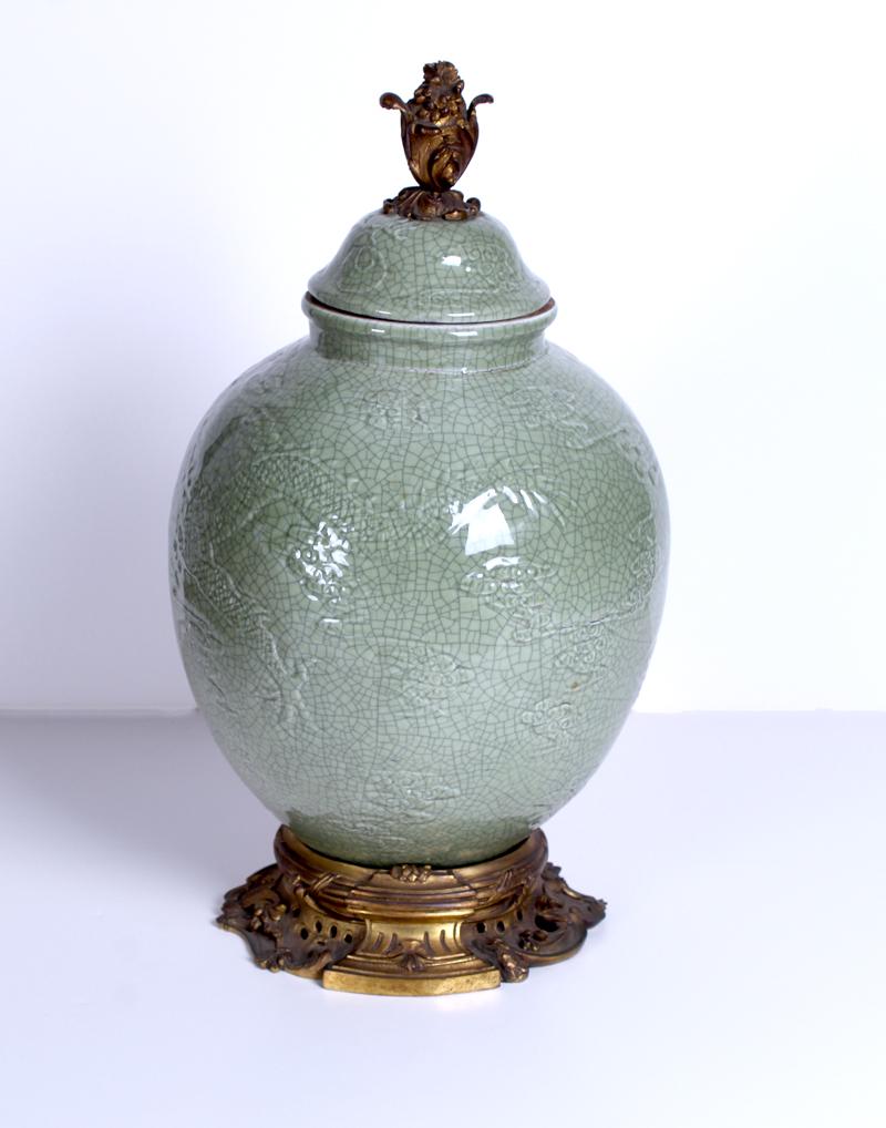 French Samson with ormolu: Lidded ginger jar with green crackle glaze and cloud motif underglaze, with bronze finial and base, overall 18” tall, 10” diameter.