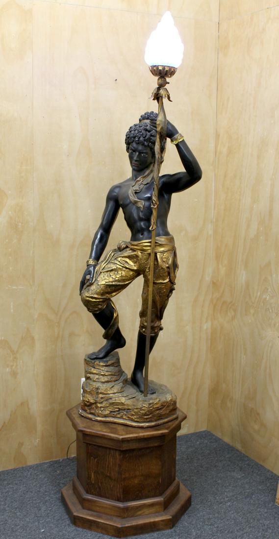 Blackamoor Torchiere Figurual Lamp: A painted wood and fiberglass figure with metal and glass lamp, stamped copyright ARP, 71 ½ x 20 x 15”, weight 32 lbs., in working order. From the collection of Chevalier Tony Clark.