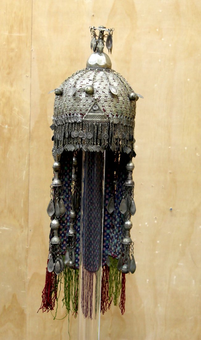 Turkmen Wedding Headdress: Metal and fabric headdress with stamped gillet, chains, bells, and tassels, overall length approximately 27”, approximately 9” diameter. From the collection of Chevalier Tony Clark.