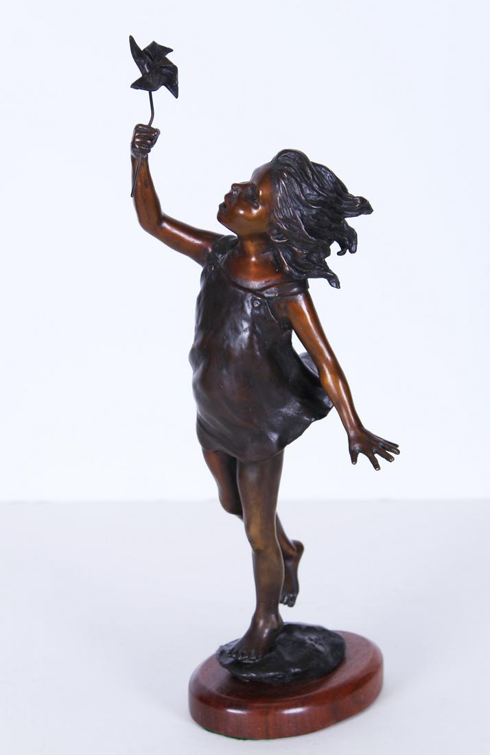 Jo Saylors (1932-2018) Oklahoma: GIRL WITH PINWHEEL, cast bronze sculpture with golden brown and dark brown patina, signed and numbered either 17/30 or 17/90, 14 ½” tall including wood base.