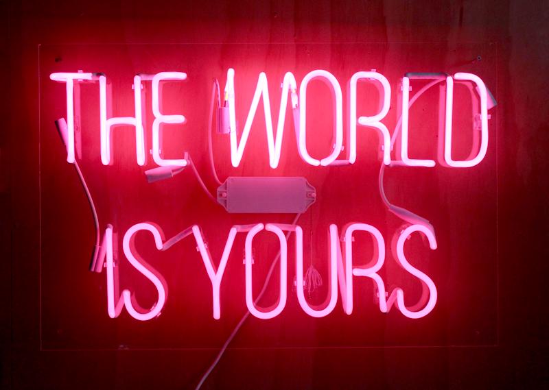 Neon Art: THE WORLD IS YOURS, neon sign mounted to Lucite, 24 x 36 x 3 ¼”.