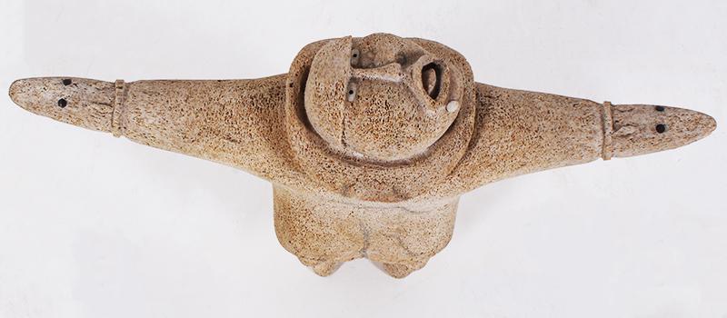 Inuit Art (20 th Century): FIGURE WITH OUTSTRETCHED ARMS, carved porous sculpture with inlay, inscribed underneath right foot, 9 x 14 ½ x 4”.
