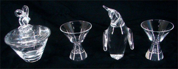 Decorative Arts: Stueben Glass (four): Capricorn lidded jar, 7 x 5 ½ x 5 ½”; a 6 ½” penguin, a pair of cocktail glasses, 4 x 3 ½ x 3 ½” each, all hallmarked underneath, all with normal surface wear, otherwise all in good conditi