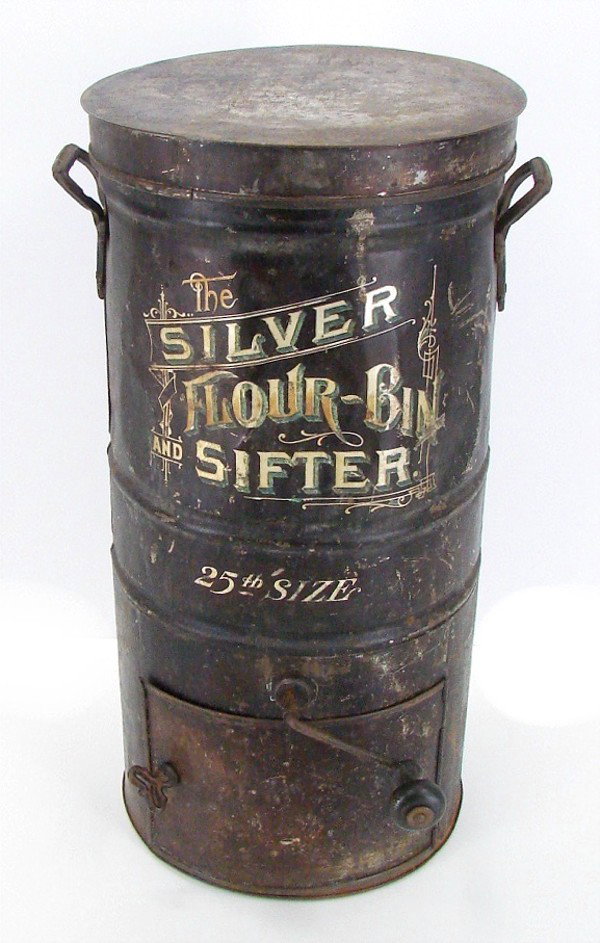 Decorative Items: Flour Sifter: The Silver Flower Bin & Sifter, 25th size, 21 ½” x 11” x 11”, worn, rusted and dented, otherwise in generally good used antique condition.