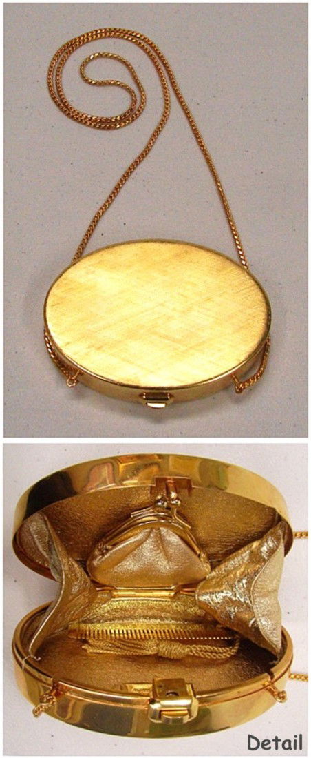 Decorative Item: Judith Leiber Purse: Gold metal purse, for use as a clutch or purse with long chain strap, gold lamee lining, with matching change purse and comb, Judith Leiber metal name plate inside, 3 ¼ x 4 ¾ x 1 ¼”.